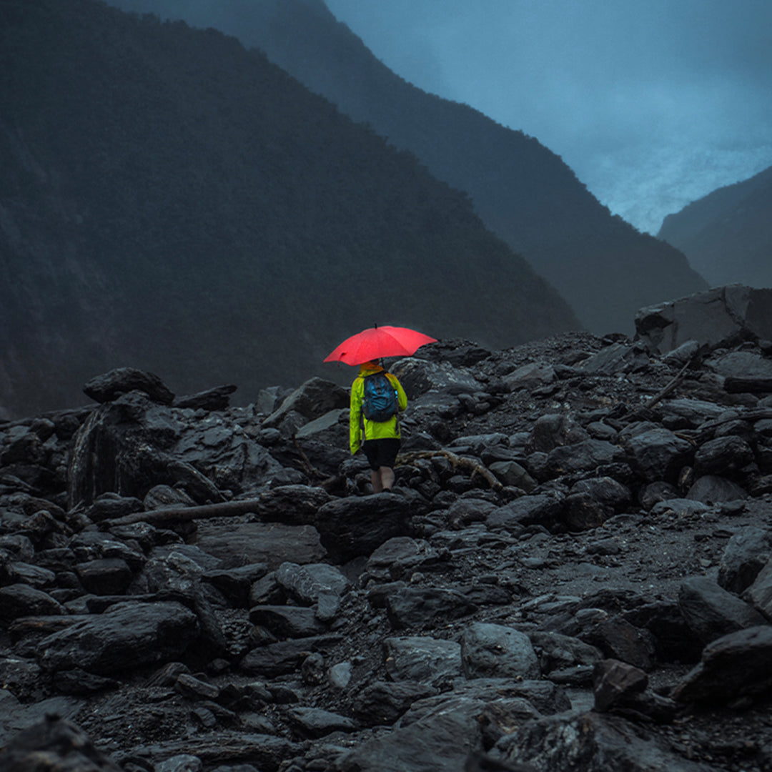 BLUNT Umbrellas Instagram Man in rocky hills with red classic umbrella